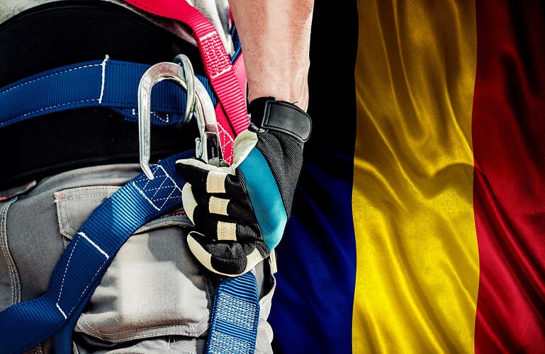 Romanian Man Standing With Safety Gear and Romanian Flag at THe Back